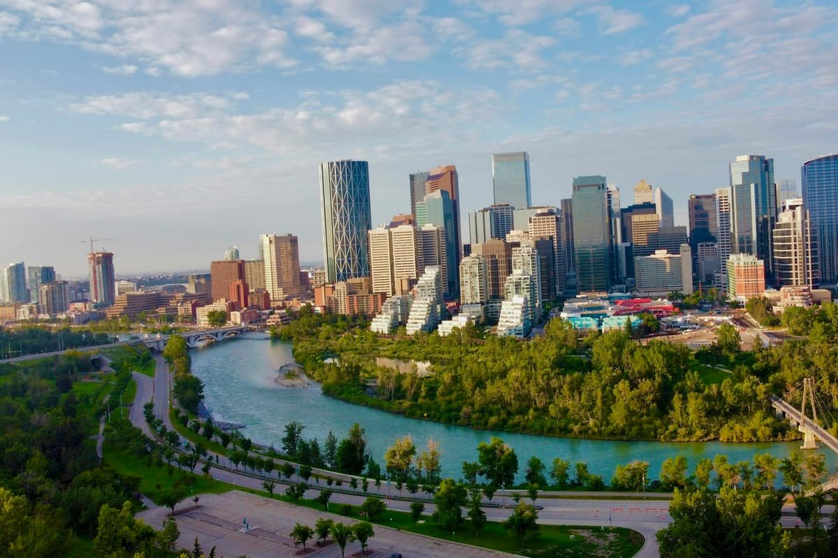 A city with a river running through it in Calgary skyline beside the Bow River at sunset, Alberta