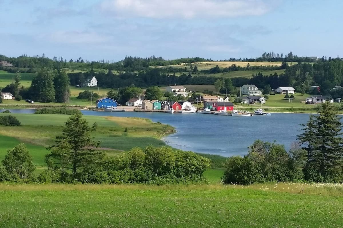 Green grass field near body of water during daytime in Charlottetown, Prince Edward Island